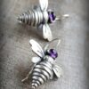 358147873_751667426959889_8717095618747760399_n Aretes de piedra púrpura con diseño de abeja pequeña